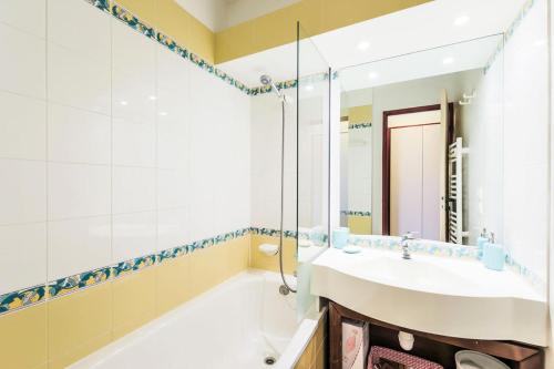 y baño con lavabo, bañera y espejo. en Résidence Le Mont Soleil - maeva Home - Appartement 2 Pièces 5 Personnes - 38 en Mâcot La Plagne