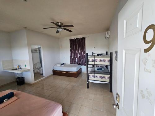 a bedroom with a bed and a ceiling fan at El Padrino in Akumal