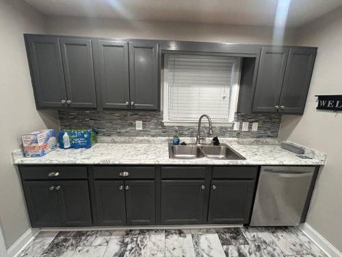 a kitchen with black cabinets and a sink at 3 bedroom, 2 bath house near tennis center in Rome