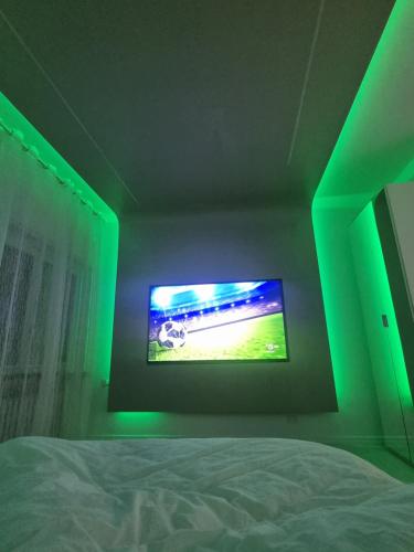 a bedroom with a green lighted tv on the wall at Appartamento Crihana in Aosta