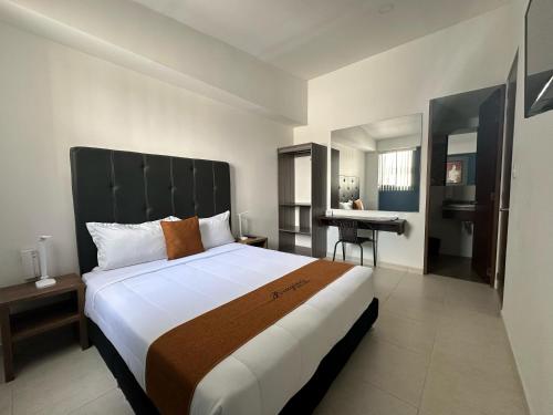 um quarto de hotel com uma cama grande e uma secretária em PERUGINO´S HOTEL GALERIA em Popayán