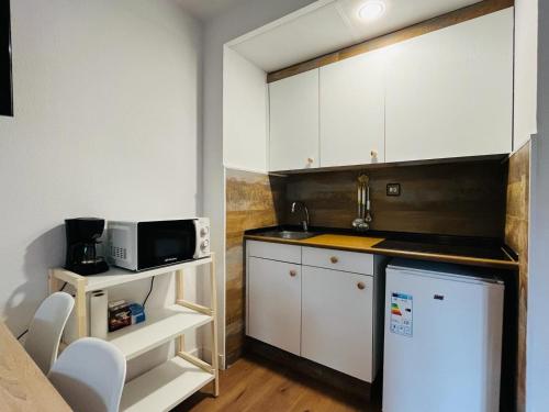 een keuken met witte kasten en een koelkast bij Encantador Apartamento en Pla de l’Ermita in Pla de l'Ermita