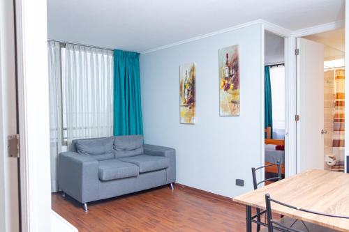 a living room with a chair and a table at Departamentos Amoblados Torre Tagle in Santiago
