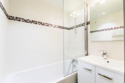 une salle de bain blanche avec un lavabo et une douche dans l'établissement Résidence Le Preyerand - Appartement 2 Pièces 6 Personnes - Sélection MAE-0896, aux Menuires