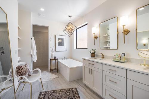 a white bathroom with a tub and a sink at Taking Flight in Ivins