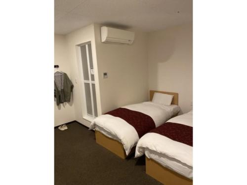 a room with two beds and a window at Fujisan Resort Hotel - Vacation STAY 57971v in Fujikawaguchiko