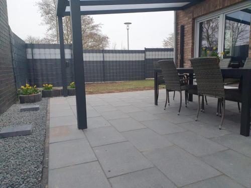 a patio with a table and chairs and a fence at Fewo RoBBe in Wangerland