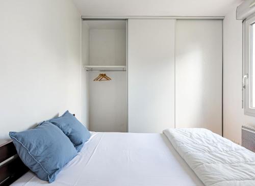 里昂的住宿－Le Bijou de Part-Dieu Grand et Charmant 2P Central，卧室配有带蓝色枕头的大型白色床