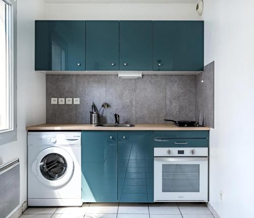 a kitchen with blue cabinets and a washing machine at Le Bijou de Part-Dieu Grand et Charmant 2P Central in Lyon