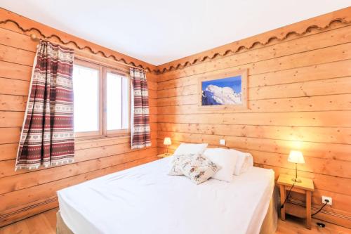 a bedroom with wooden walls and a bed with white sheets at Résidence L'Ecrin des Neiges - maeva Home - Appartement 4 Pièces 8 Personnes - Sélection MAE-2873 in Tignes