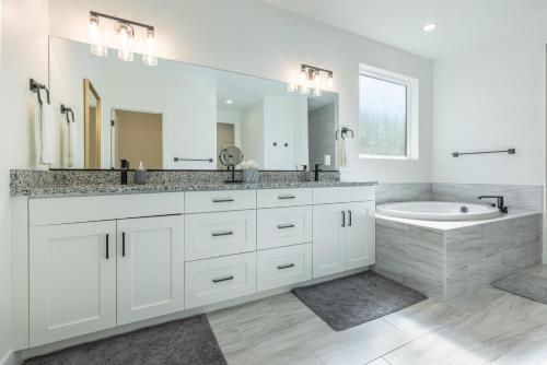 a white bathroom with a large mirror and a sink at Casa Ledges in Ivins