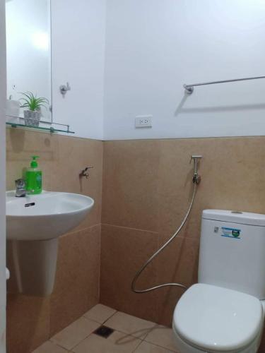 a bathroom with a white toilet and a sink at Humble Abode de Gloria in Manila