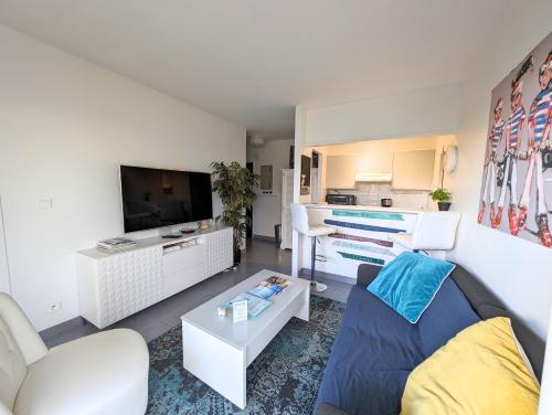 un salon avec un canapé et une télévision dans l'établissement Les pieds dans le sable de la Plage Benoît - T2, à La Baule
