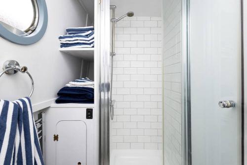 a bathroom with a shower with blue and white towels at Lazy Days Narrow Boat in Stanley