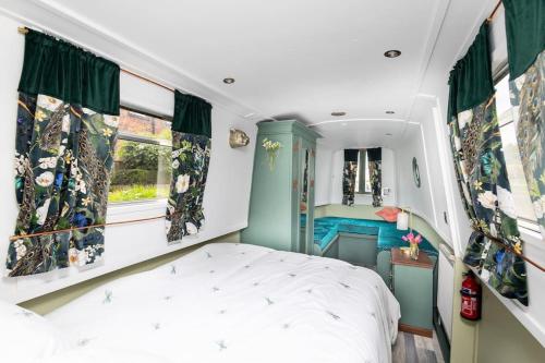 Schlafzimmer mit einem Bett, einem Waschbecken und einem Spiegel in der Unterkunft Lazy Days Narrow Boat in Stanley