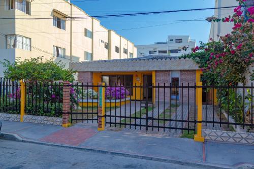 una cerca negra frente a un edificio con flores en Colonial Beach Airport Hotel, en Cartagena de Indias