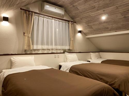 Habitación con 2 camas y ventana en Rental Villa Karuizawa Honors Hill - Vacation STAY 02160v en Oiwake