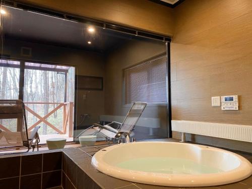 OiwakeにあるRental Villa Karuizawa Honors Hill - Vacation STAY 02336vのバスルーム(バスタブ付)、窓際の椅子