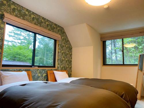 OiwakeにあるRental Villa Karuizawa Honors Hill - Vacation STAY 02336vのベッドルーム1室(ベッド2台、窓2つ付)