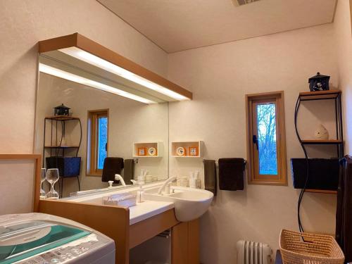 uma casa de banho com um lavatório e um espelho grande em Rental Villa Karuizawa Honors Hill - Vacation STAY 71491v em Oiwake