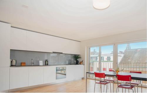 巴塞爾的住宿－Modern Apartment in the heart of Basel，厨房配有白色橱柜和红色椅子的桌子
