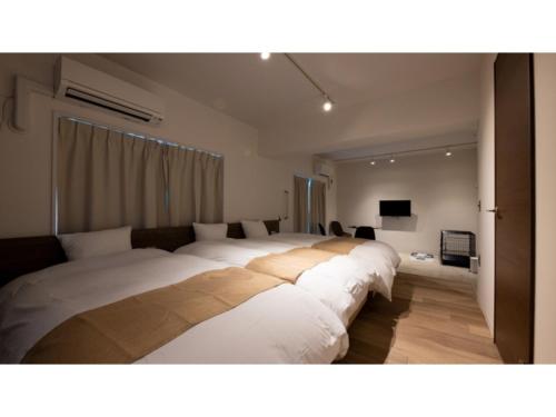 um quarto com 2 camas grandes e uma televisão em River Side Arashiyama - Vacation STAY 86277v em Quioto