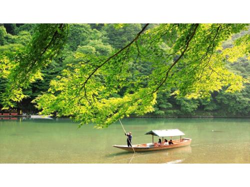 a man standing on a boat in the water at River Side Arashiyama - Vacation STAY 86277v in Kyoto