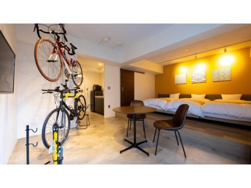 um quarto com uma cama e uma bicicleta pendurada numa parede em River Side Arashiyama - Vacation STAY 86248v em Quioto