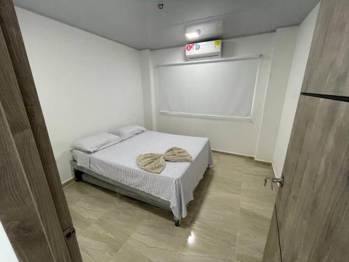 Un pequeño dormitorio con una cama con toallas. en Casa con piscina privada Santa Ana, en Flandes