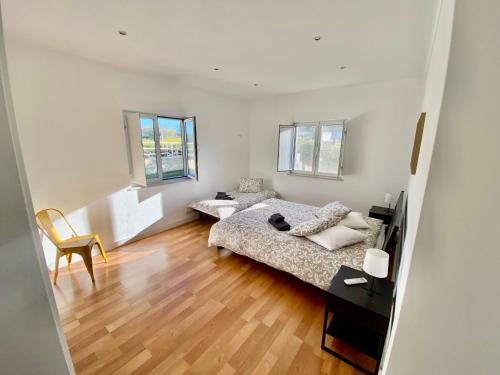 a bedroom with two beds and a table and a chair at Pôr-do-sol Villa in São Pedro do Corval