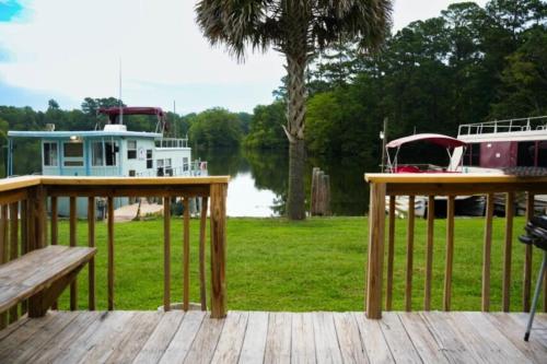 EutawvilleBells Marina & Fishing Resort - Santee Lake Marion by I95 - Family Adventure, Pets on Request!的甲板上有长椅，水面上停着一艘船。