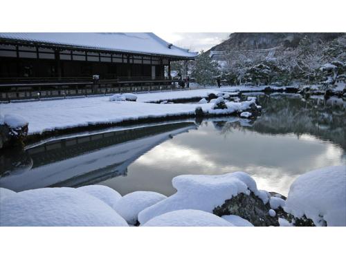 a river covered in snow next to a building at River Side Arashiyama - Vacation STAY 86224v in Kyoto