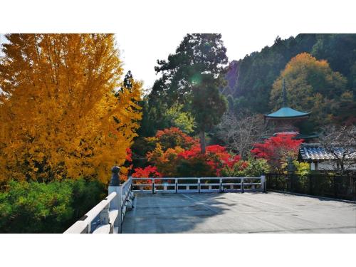 a garden with colorful trees and a fence at River Side Arashiyama - Vacation STAY 86224v in Kyoto