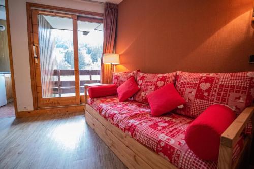 salon z czerwoną kanapą i czerwonymi poduszkami w obiekcie MUCILLON G - Appartement MUCILLON 21 pour 6 Personnes 99 w mieście Valmorel