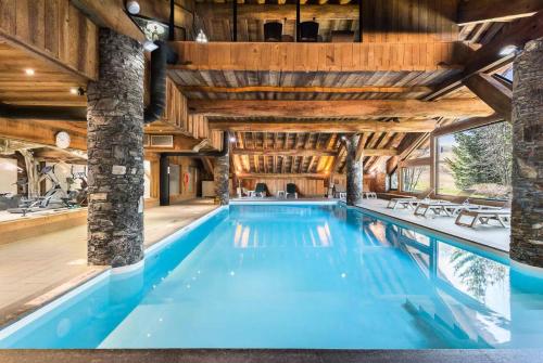 een binnenzwembad in een huis met houten plafonds bij Résidence Ferm C - 3 Pièces pour 5 Personnes 934 in Les Allues