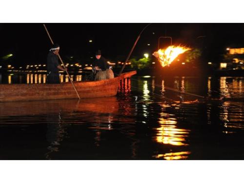 two men in a boat with a fire in the water at River Side Arashiyama - Vacation STAY 86224v in Kyoto