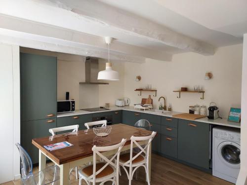 une cuisine avec une table et des chaises dans une cuisine dans l'établissement Maison de vacances - 3 chambres - proximité plage, à Bénodet