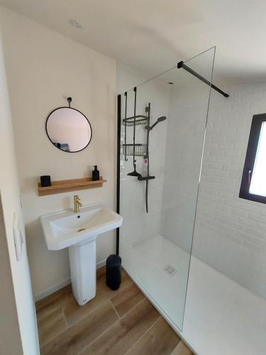 une salle de bain blanche avec un lavabo et une douche dans l'établissement Maison de vacances - 3 chambres - proximité plage, à Bénodet