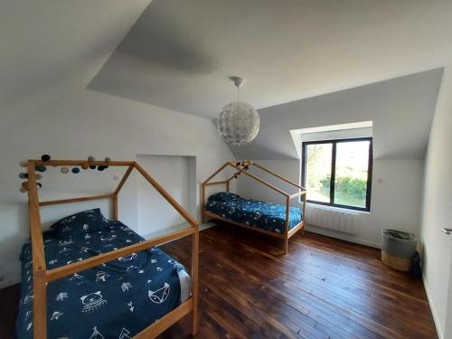 une chambre avec deux lits superposés et une fenêtre dans l'établissement Maison de vacances - 3 chambres - proximité plage, à Bénodet