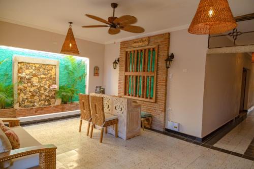 a living room with a ceiling fan and a table and chairs at Colonial Beach Airport Hotel in Cartagena de Indias