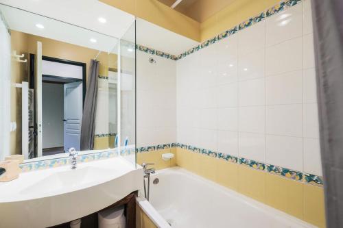 une salle de bain avec une baignoire et un lavabo dans l'établissement Résidence La Marelle et Le Rami - maeva Home - Appartement 2 Pièces 5 Personnes - Sélection MAE-7484, à La Plagne Tarentaise