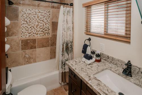 a bathroom with a tub and a sink and a shower at Pantai Inn in San Diego
