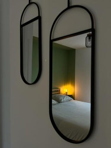 un miroir sur un mur à côté d'un lit dans l'établissement A l’ancienne école, à Saint-Ours