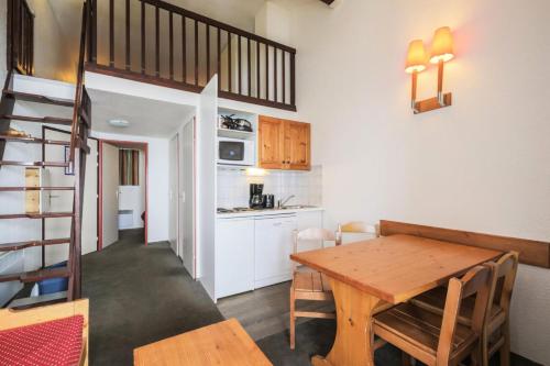 une cuisine et une salle à manger avec une table en bois dans l'établissement Résidence Les Horizons d'Huez - maeva Home - Appartement 2 Pièces 6 Personnes - Budget MAE-7008, à Huez