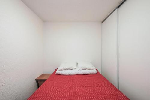 - une chambre blanche avec un lit rouge dans l'établissement Résidence Les Horizons d'Huez - maeva Home - Appartement 2 Pièces 6 Personnes - Budget MAE-7008, à Huez
