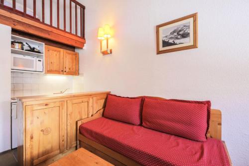 - un salon avec un canapé rouge et un four micro-ondes dans l'établissement Résidence Les Horizons d'Huez - maeva Home - Appartement 2 Pièces 6 Personnes - Confort MAE-8120, à Huez