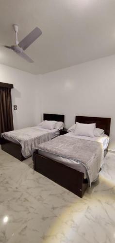 two twin beds in a room with a ceiling at Elminaa Residence 6 in Luxor