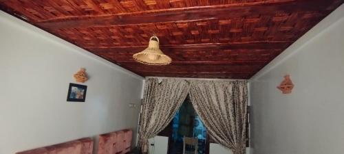 a room with a wooden ceiling and a window at Gite akswal amssakrou in Ikis