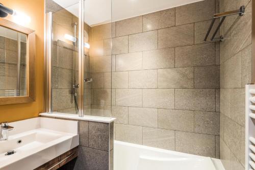 a bathroom with a tub and a sink and a shower at Résidence Arietis - Atria-Crozats - maeva Home - Appartement 2 Pièces 5 Personnes - Prestige MAE-8129 in Morzine