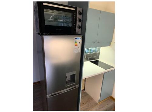 un micro-ondes au-dessus d'un réfrigérateur dans une cuisine dans l'établissement Quartier Crève Cœur - maeva Home - Studio 5 personnes Sélection MAE-2906, à Valmorel